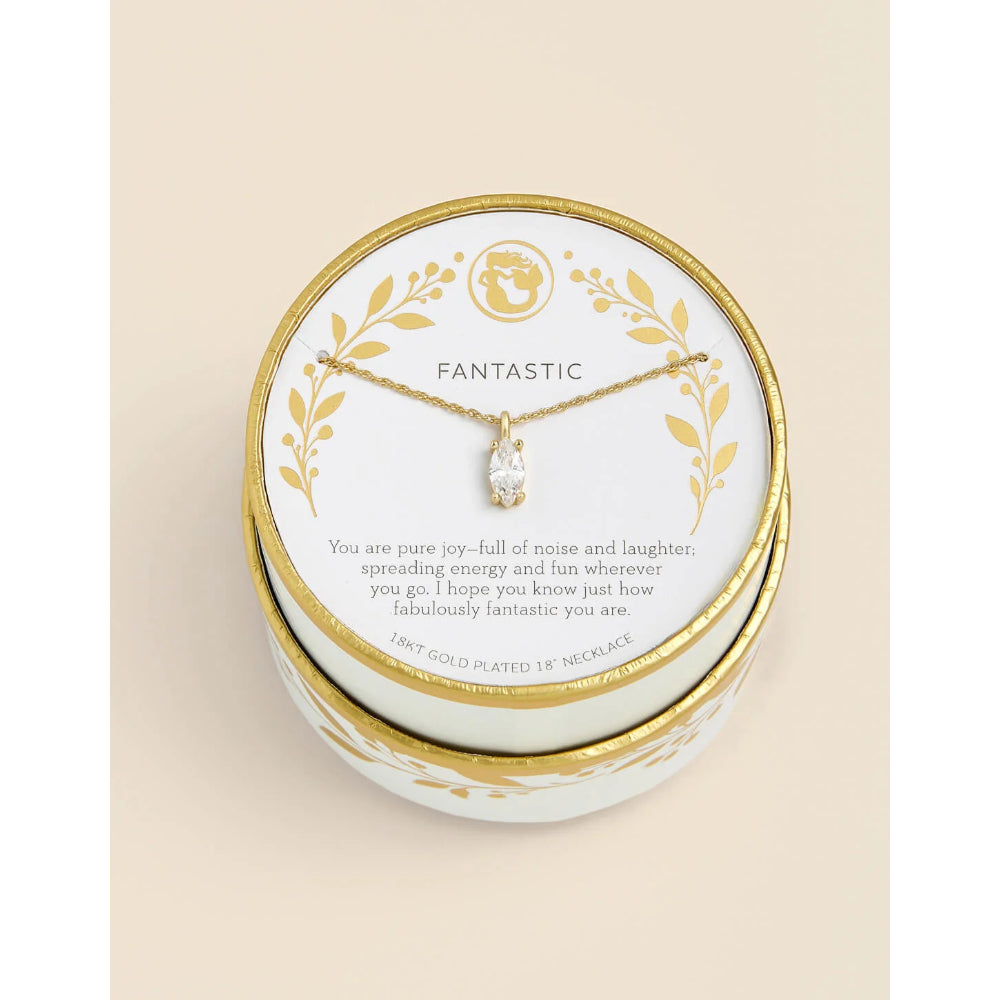 A gold-plated 18-inch necklace with a clear faceted pendant displayed on a white card inside a round white gift box with gold trim, set against a light beige background.