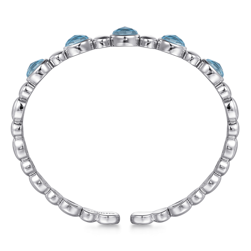 Silver ring with blue gemstones on a white background