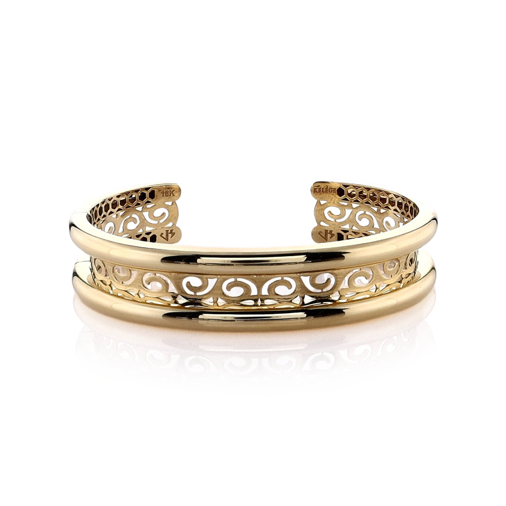 Polished yellow gold filigree center bangle bracelet on a white background