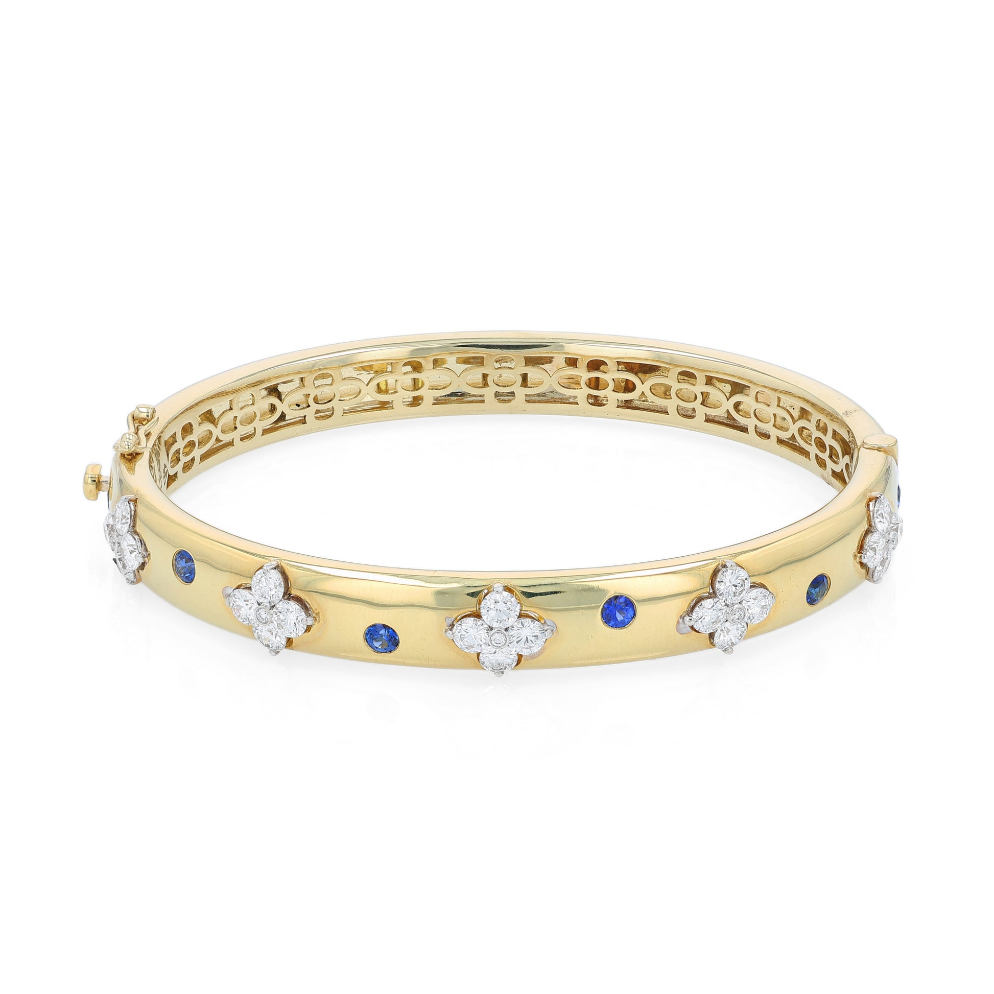 Gold bracelet with diamond and sapphire accents on a white background