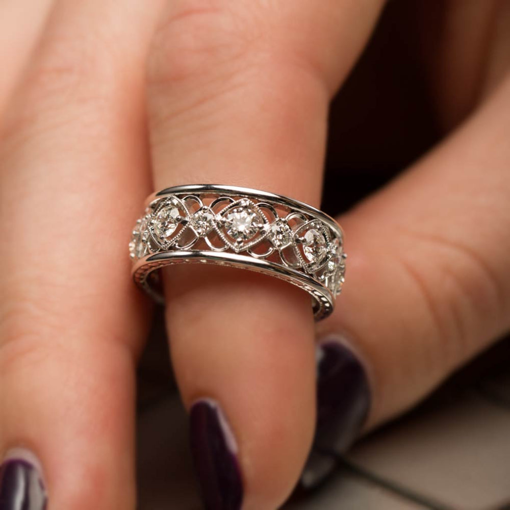 White gold diamond ring with intricate design on a finger