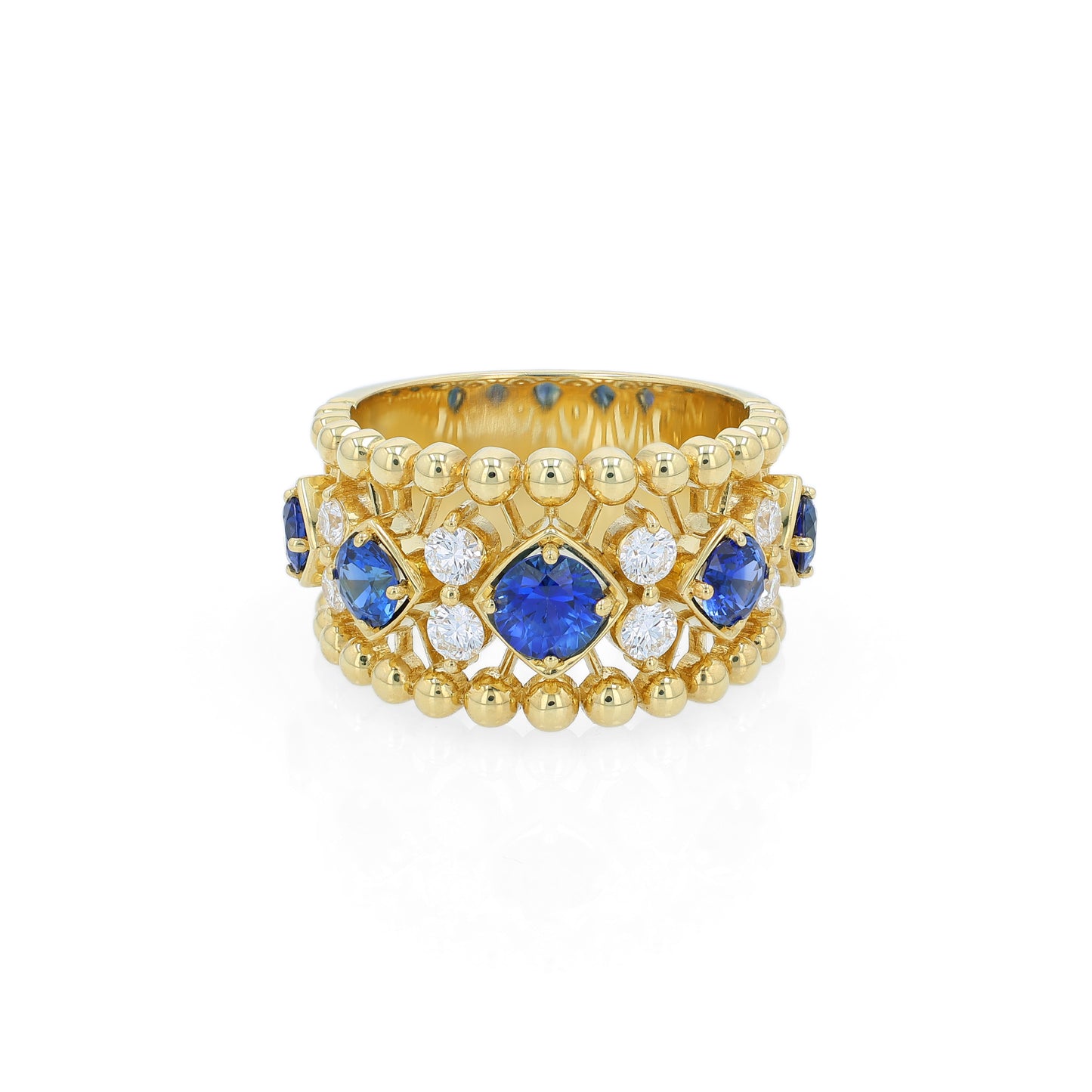 Yellow gold open work ring with diamond and blue sapphire accents on a white background