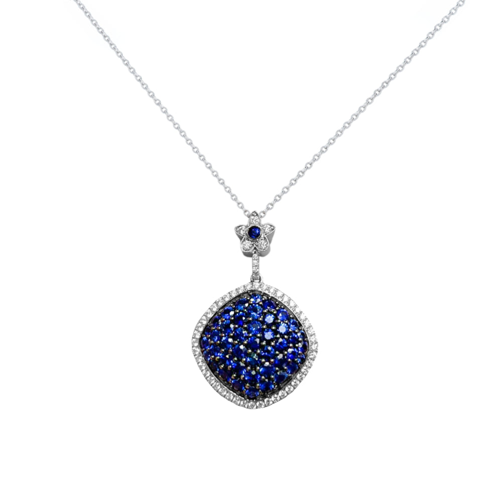 White gold diamond halo pendant necklace with a pave sapphire center on a white background
