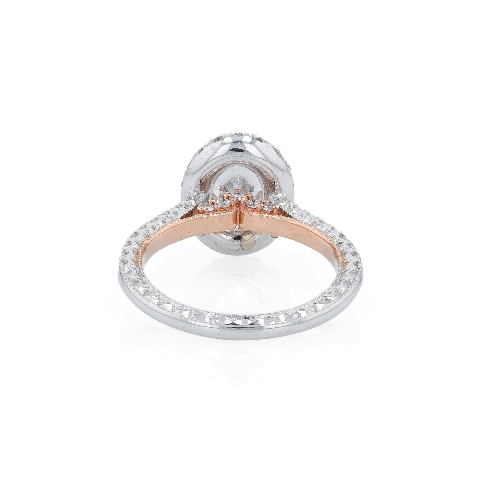 White and rose gold and diamond halo engagement ring with diamond accents and an oval cubic zirconia center on a white background
