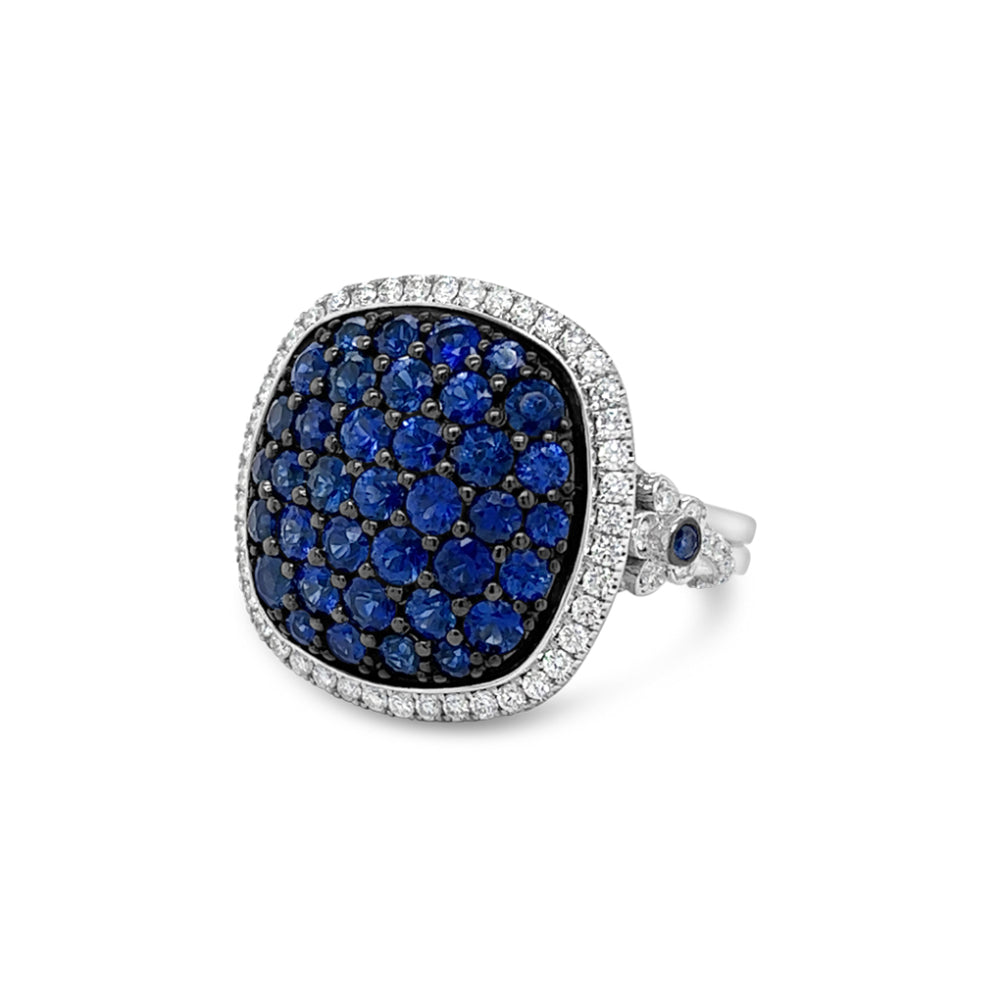 White gold diamond halo ring with a pave sapphire center on a white background