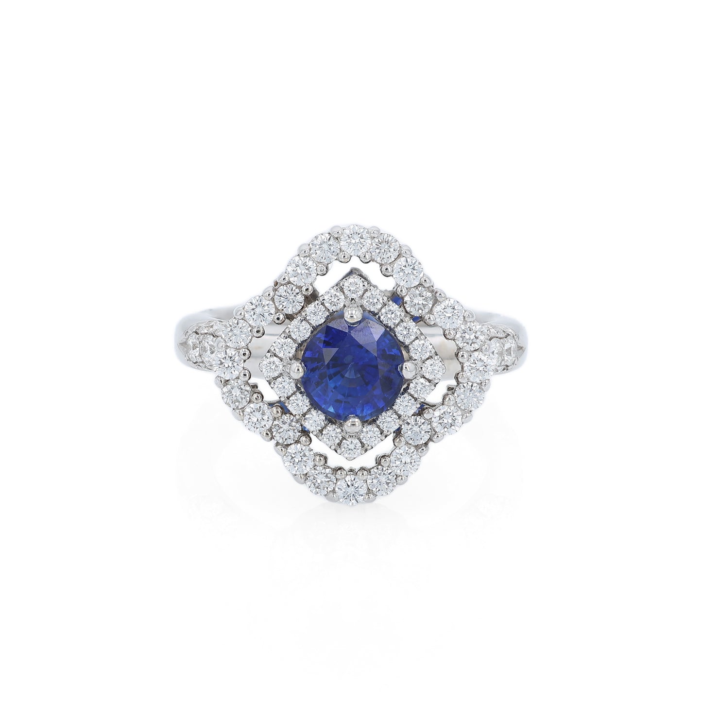 White gold diamond double halo ring with a blue sapphire center stone on a white background