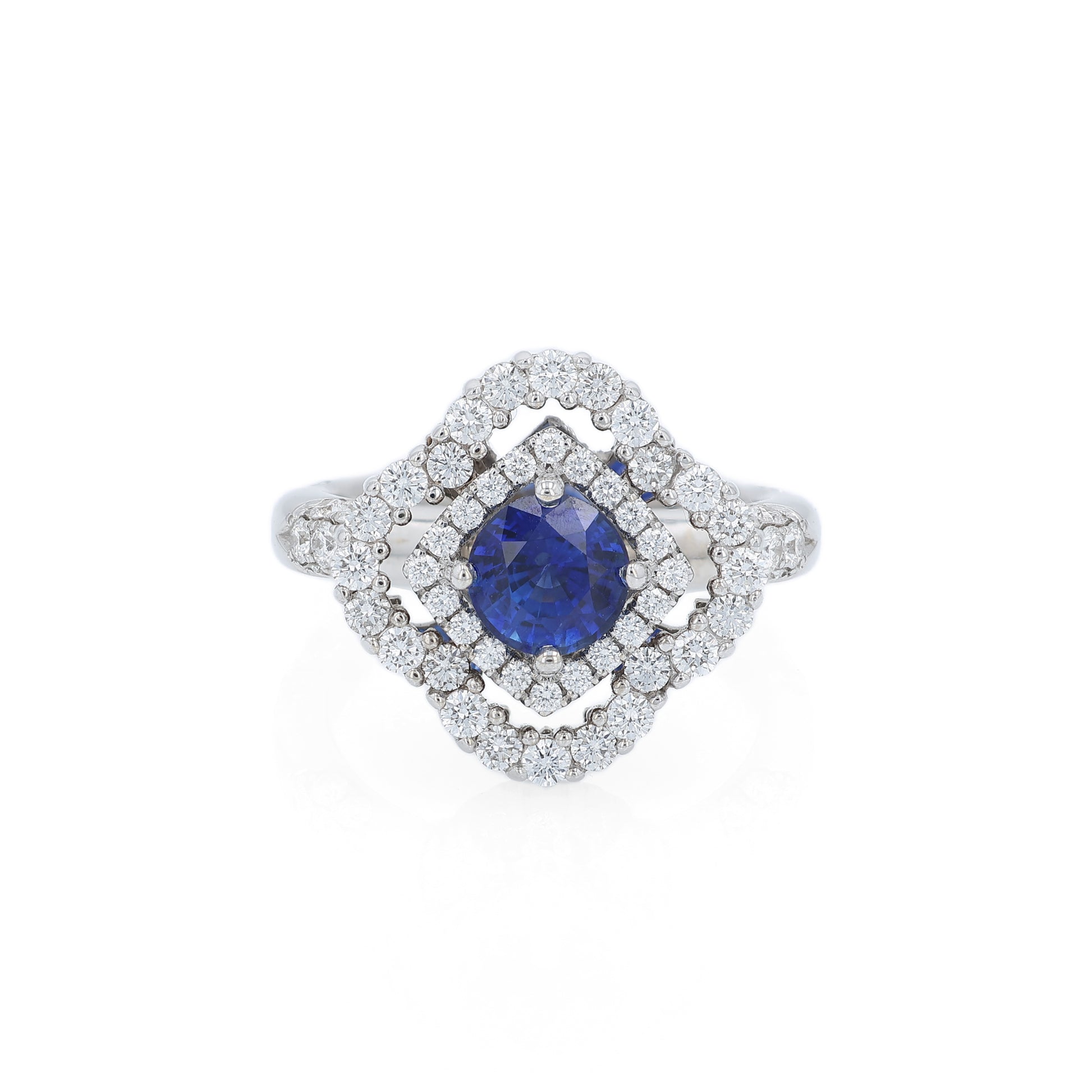 White gold diamond double halo ring with a blue sapphire center stone on a white background