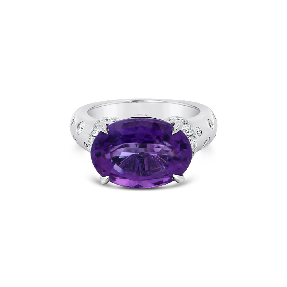 White gold ring with an oval amethyst center and diamond accents on a white background