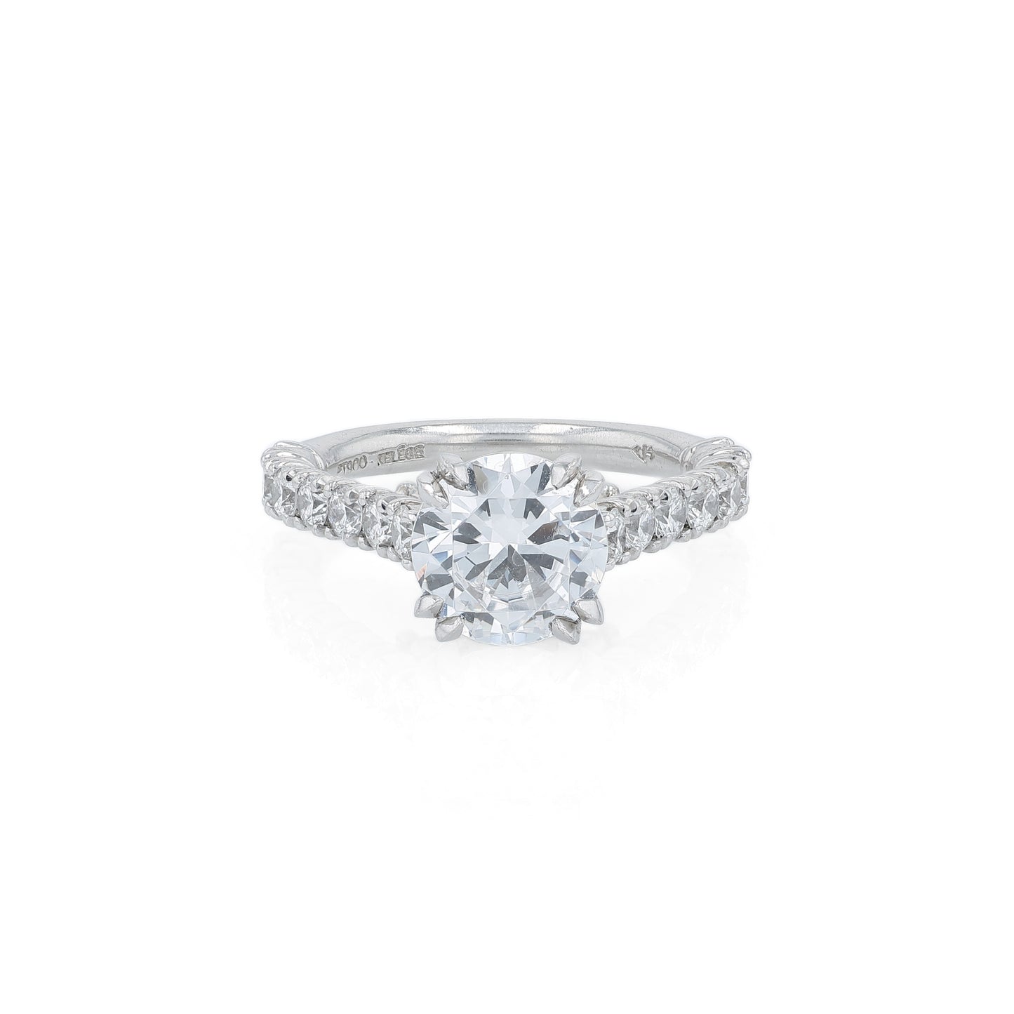Platinum diamond engagement ring with diamond accents and a round cubic zirconia center on a white background