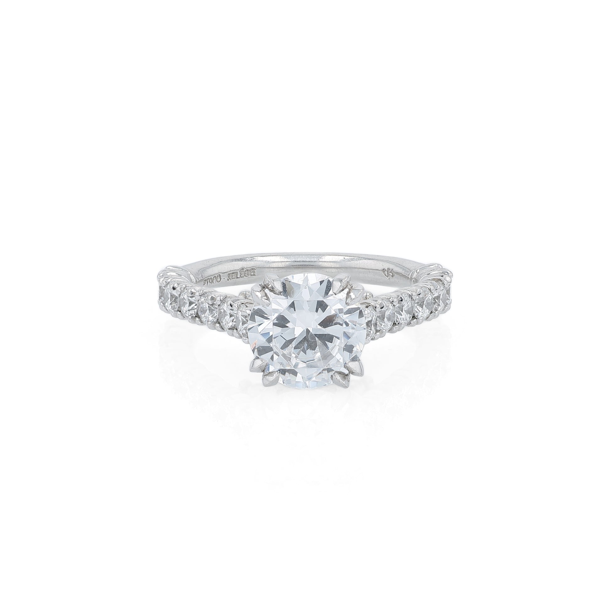 Platinum diamond engagement ring with diamond accents and a round cubic zirconia center on a white background