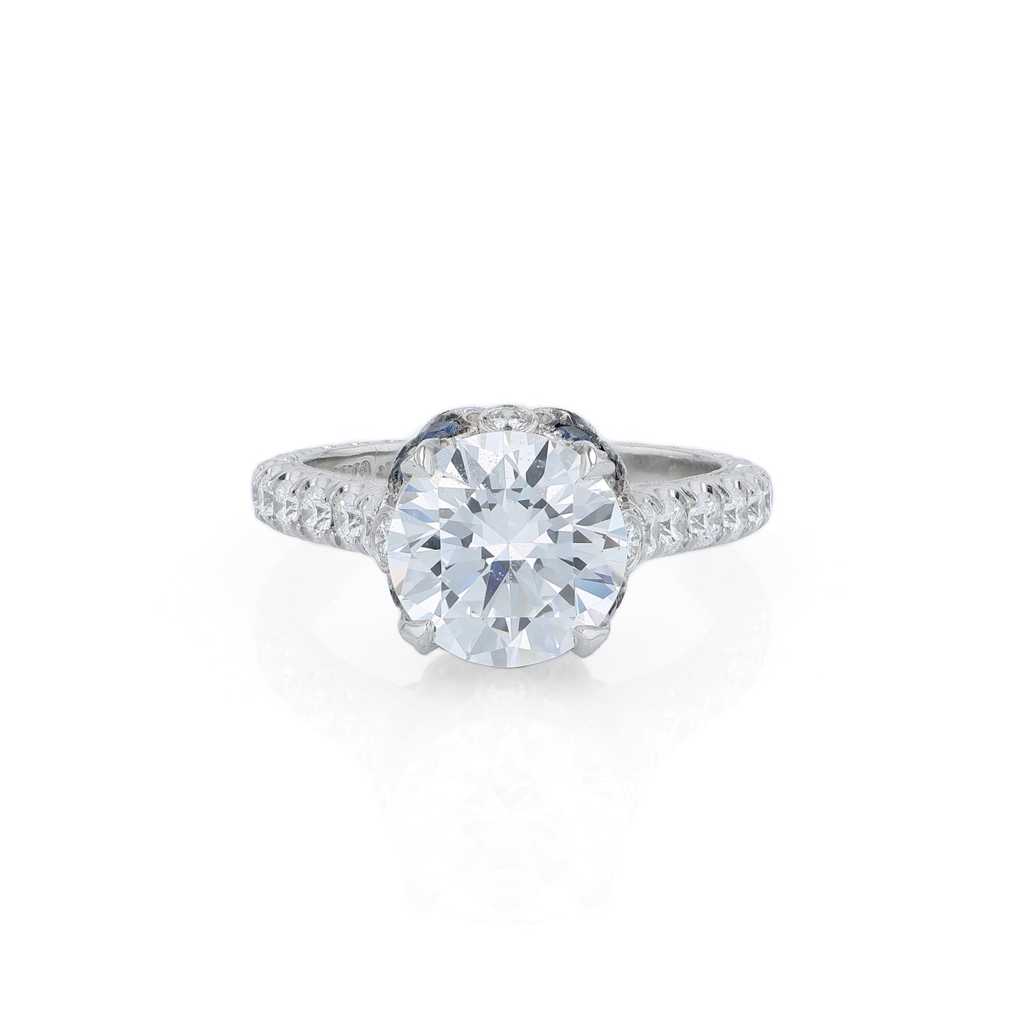 Platinum diamond engagement ring with diamond and sapphire accents and a round cubic zirconia center on a white background