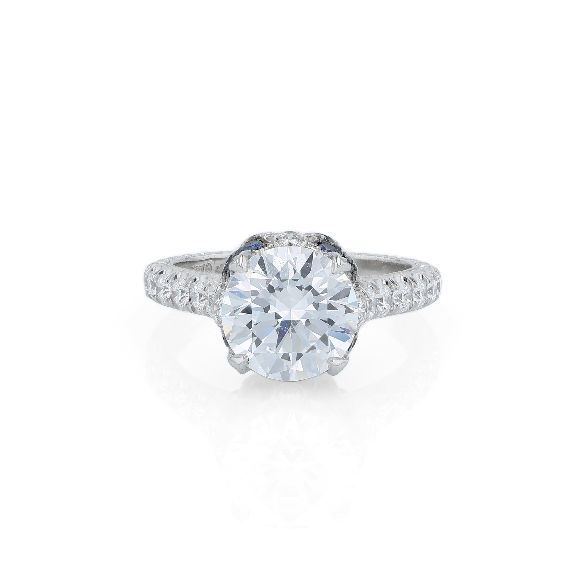 Platinum diamond engagement ring with diamond and sapphire accents and a round cubic zirconia center on a white background