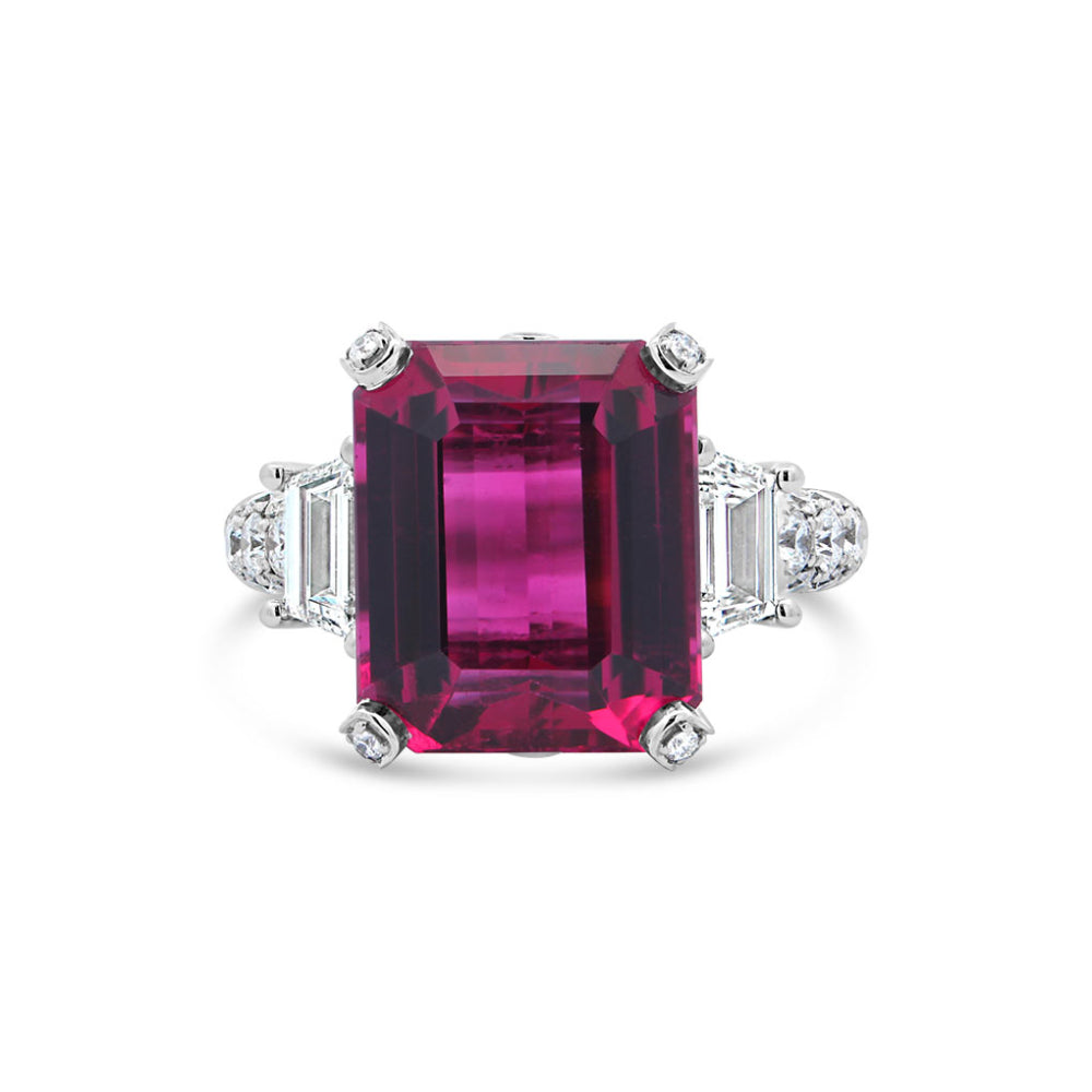 Platinum ring with a rubellite center and diamond accents on a white background