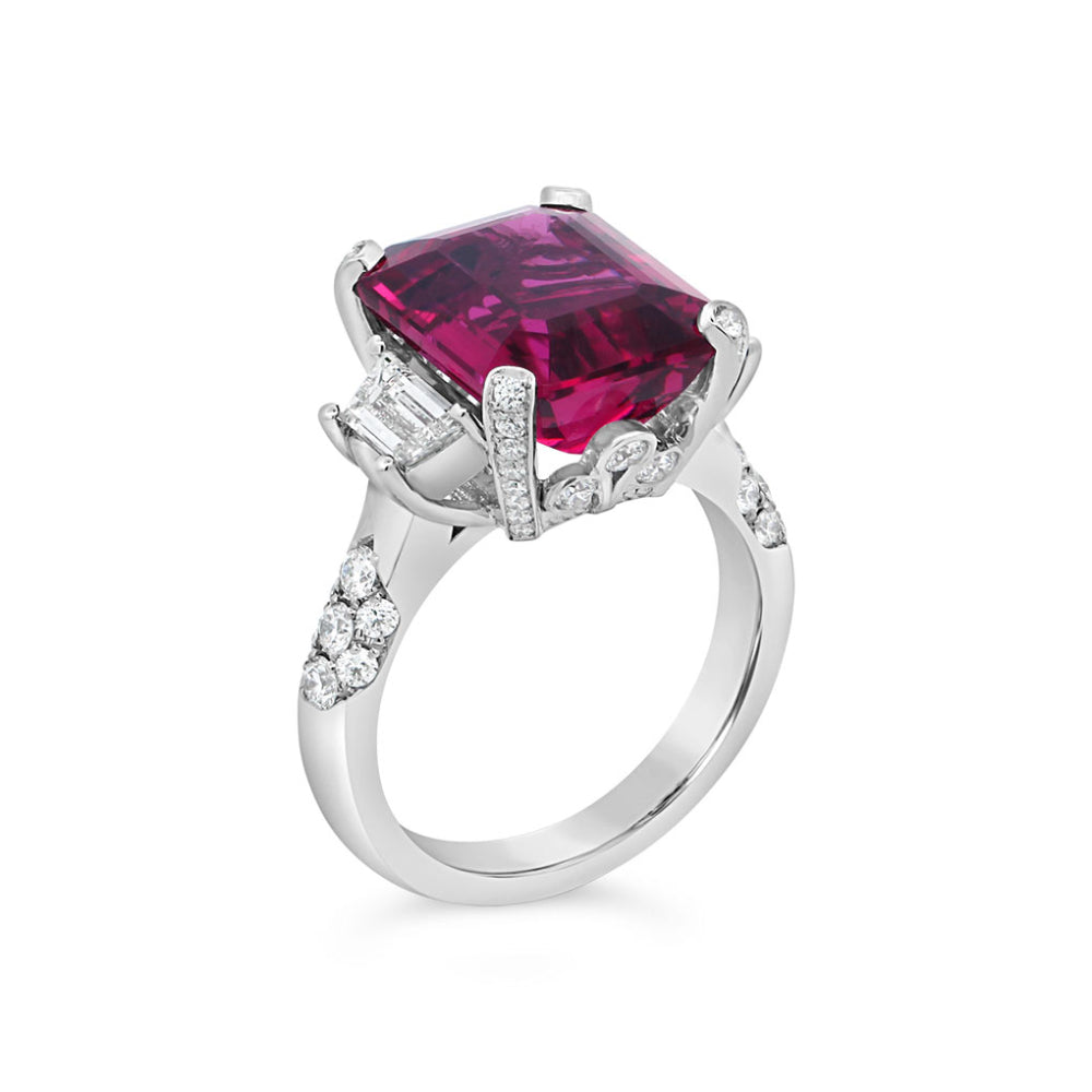 Platinum ring with a rubellite center and diamond accents on a white background