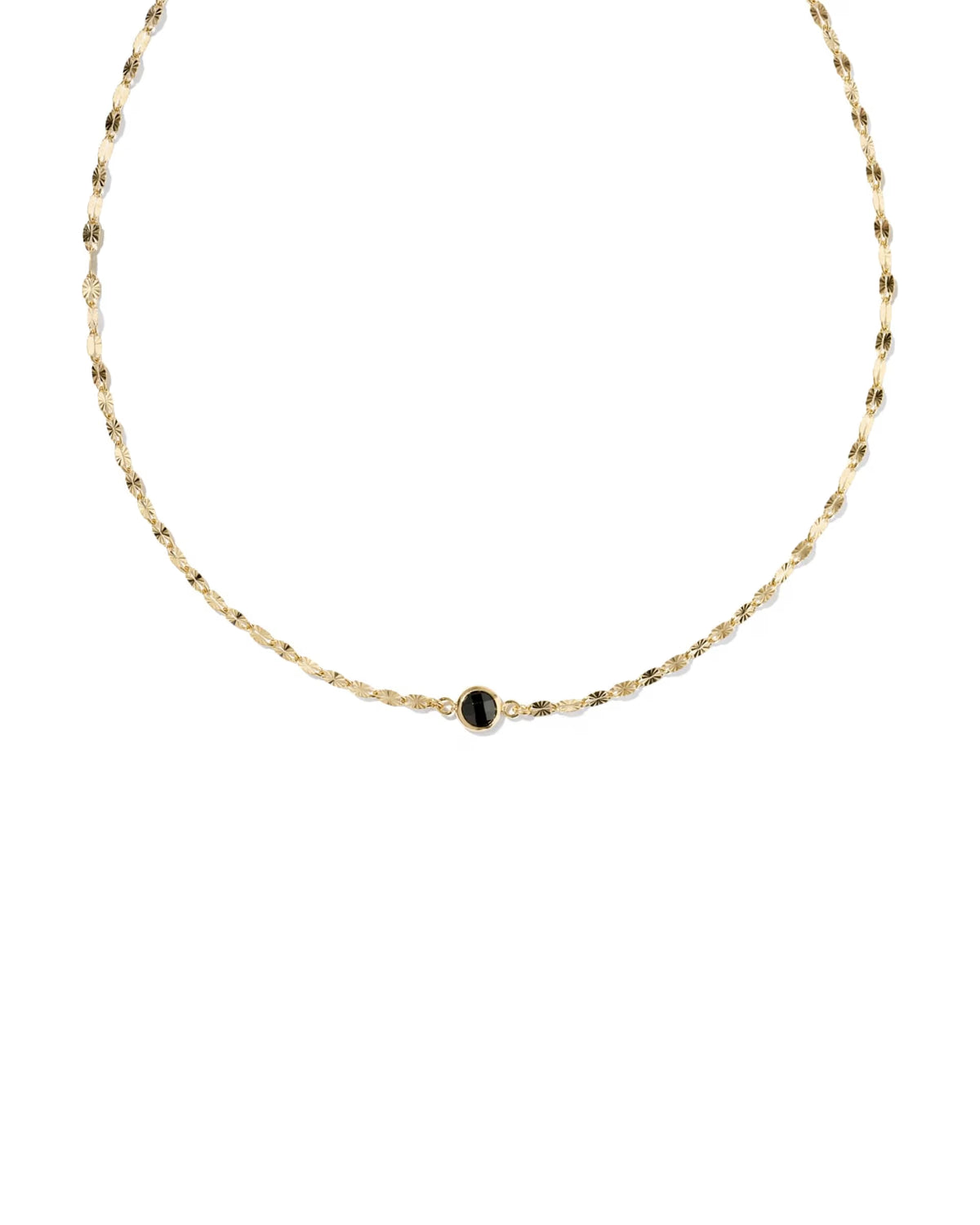 A delicate gold chain necklace featuring a small central oval black onyx stone, displayed against a solid white background.
