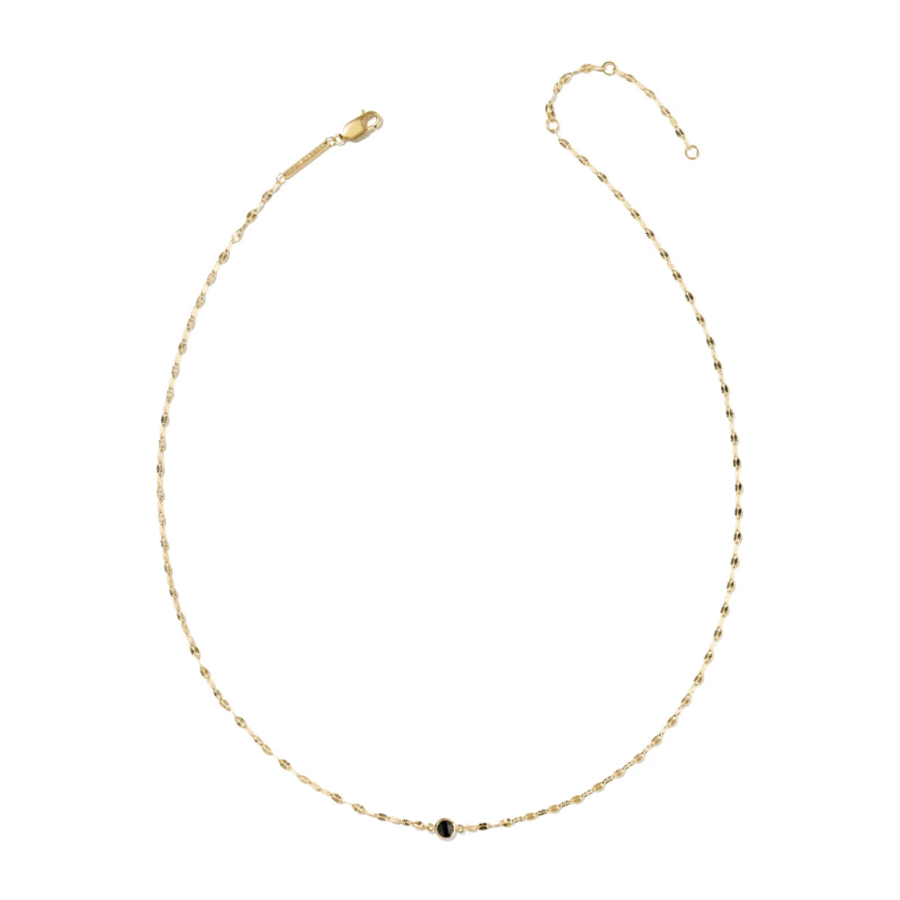A delicate gold chain necklace with a single small dark round stone set at the center, displayed on a clean white background.