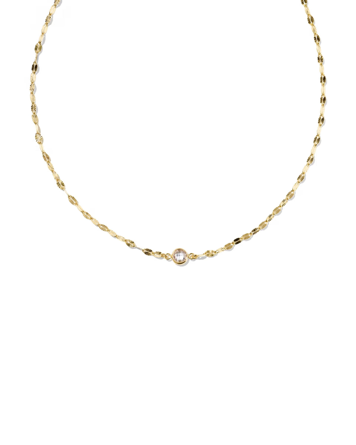 A delicate gold chain necklace featuring a small central bezel-set clear gemstone, displayed against a solid white background.