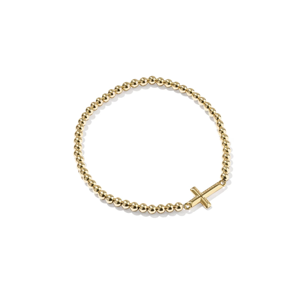 A gold beaded bracelet with a small cross charm, displayed on a clean white background.