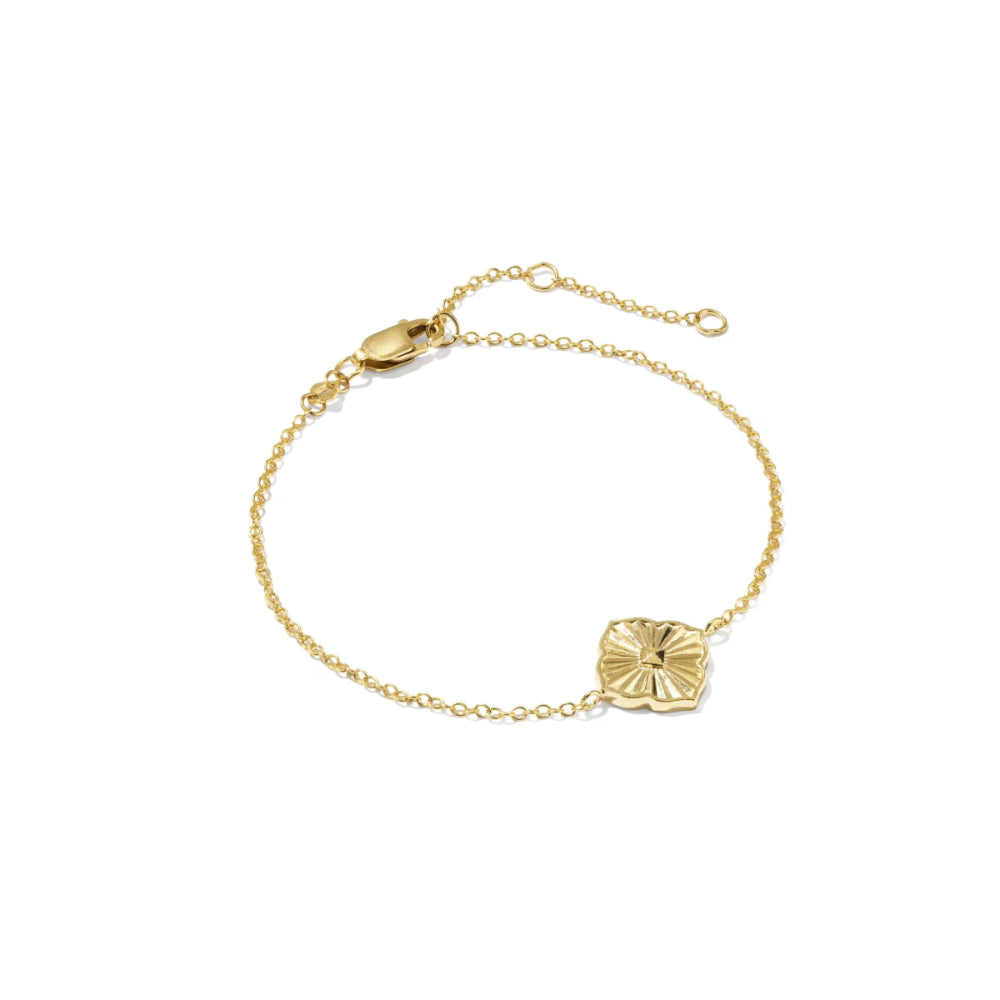 A delicate gold chain bracelet with a small textured, flower-like gold charm, displayed on a clean white background.