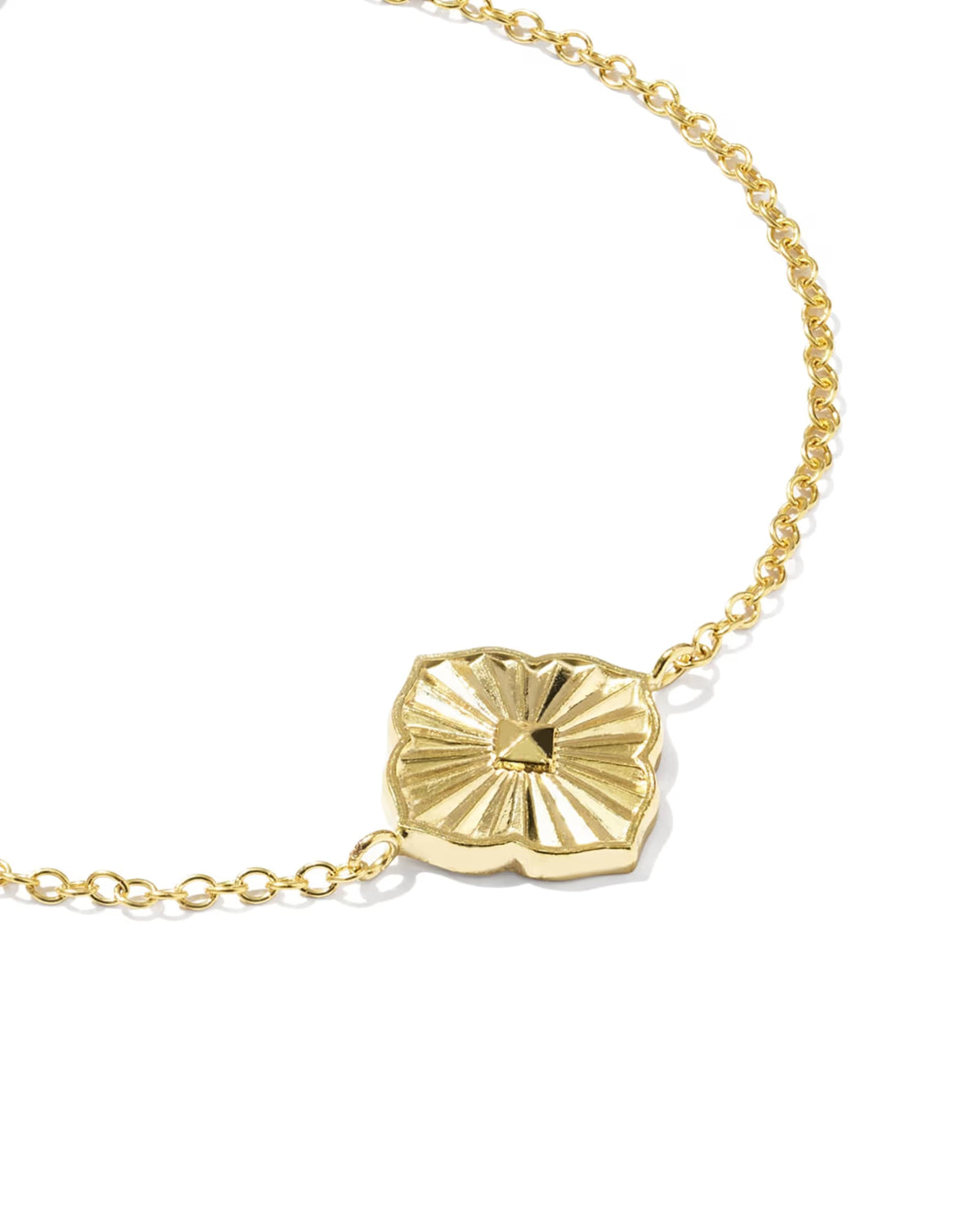 A gold chain bracelet featuring a textured, sunburst-style oval pendant, photographed on a clean white background.