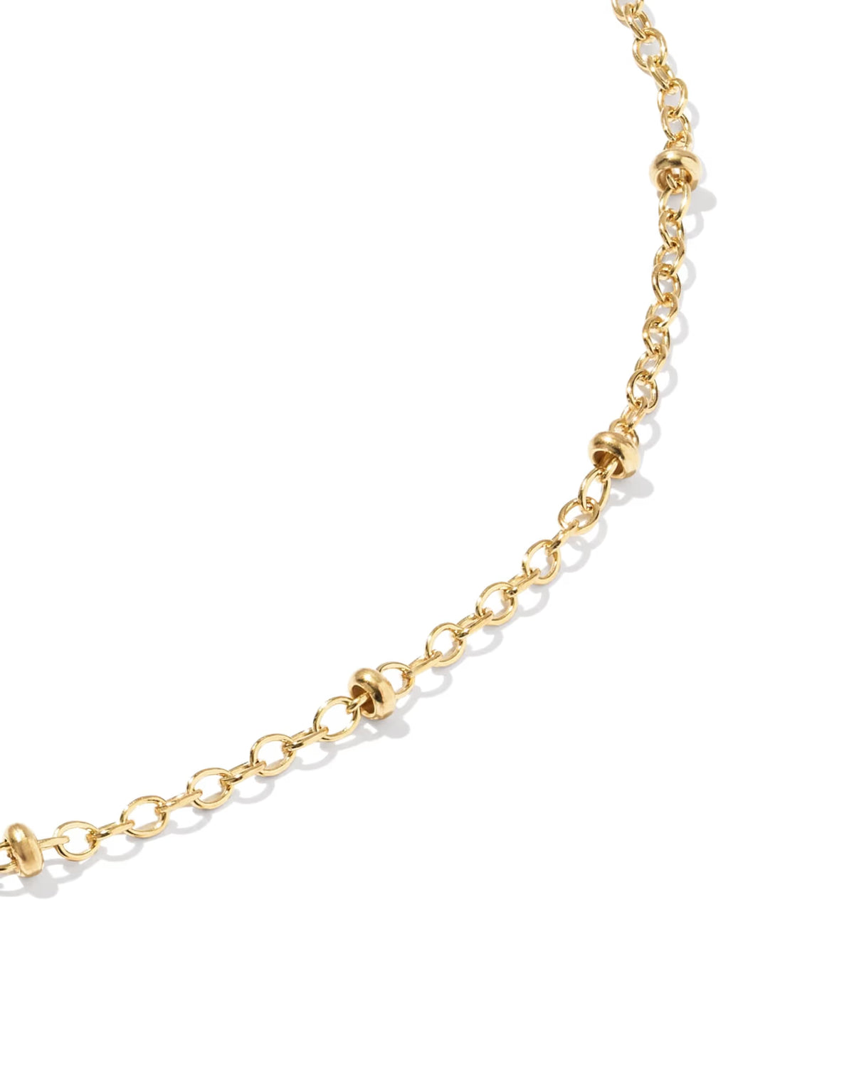 A close-up of a gold chain anklet featuring textured, knotted ball links, photographed on a clean white background.