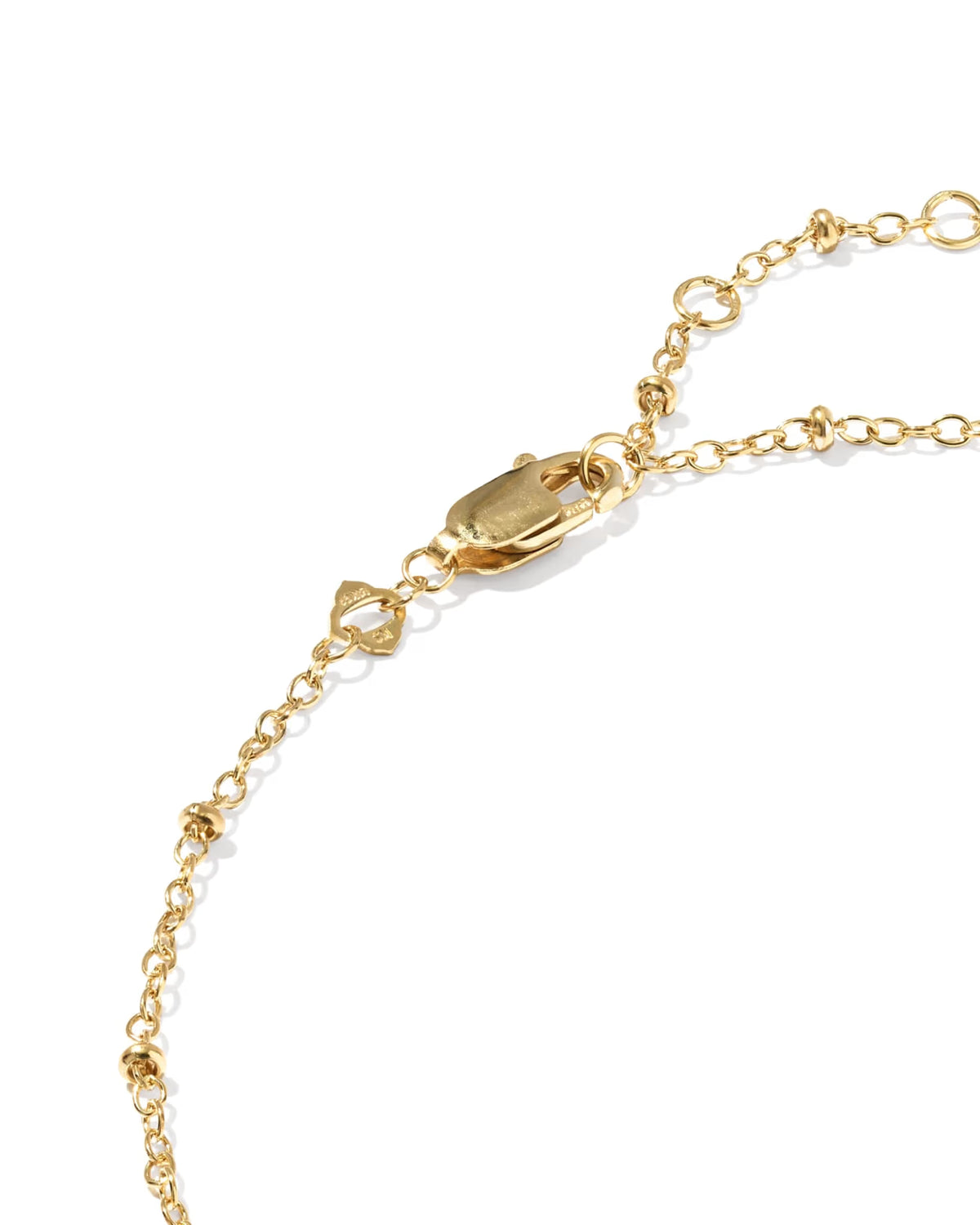 A close-up of a gold chain anklet focused on the lobster clasp featuring textured, knotted ball links, photographed on a clean white background.