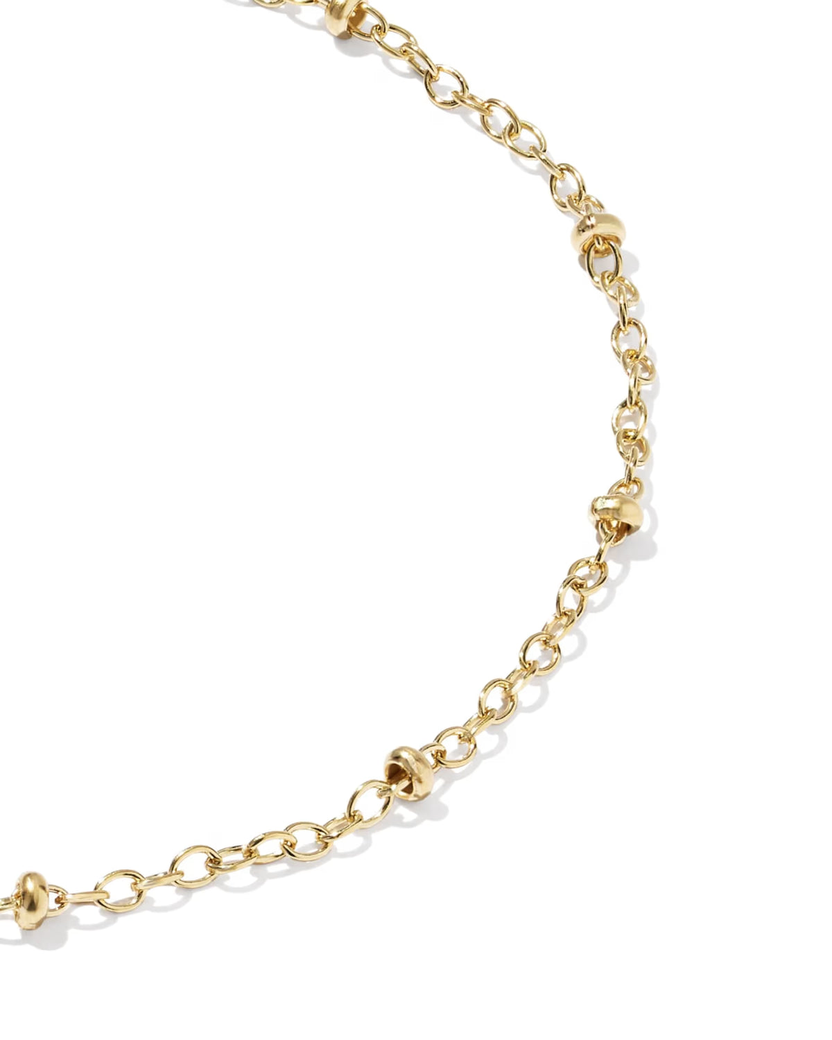 A close-up of a gold chain necklace featuring textured, knotted details at intervals, photographed on a clean white background.