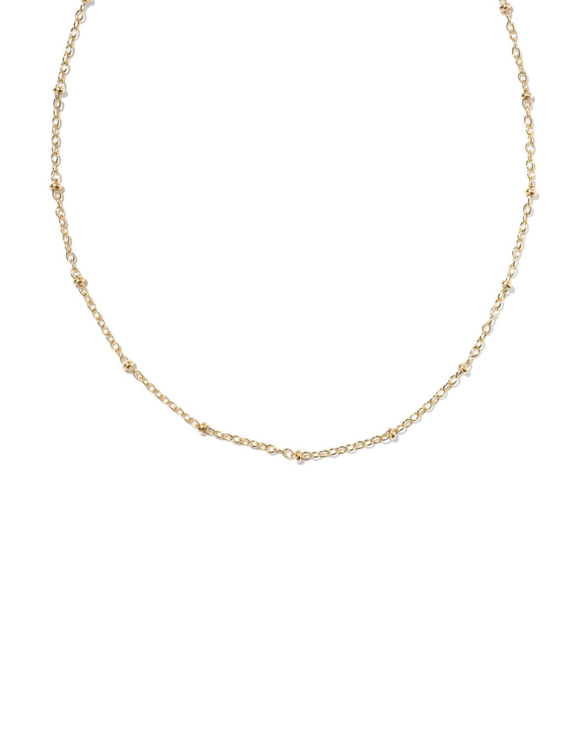 A delicate gold chain necklace with small, evenly spaced round stations, displayed against a solid white background.