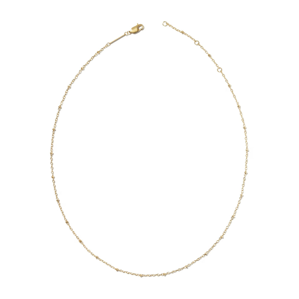 A delicate gold chain necklace with a lobster clasp, displayed in a curved oval shape against a solid white background.