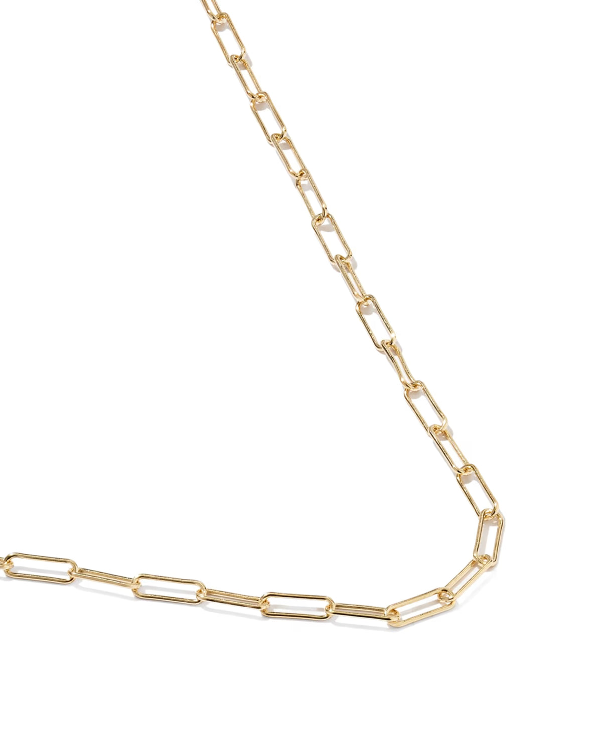 A gold paperclip chain necklace laid out diagonally on a clean white background.