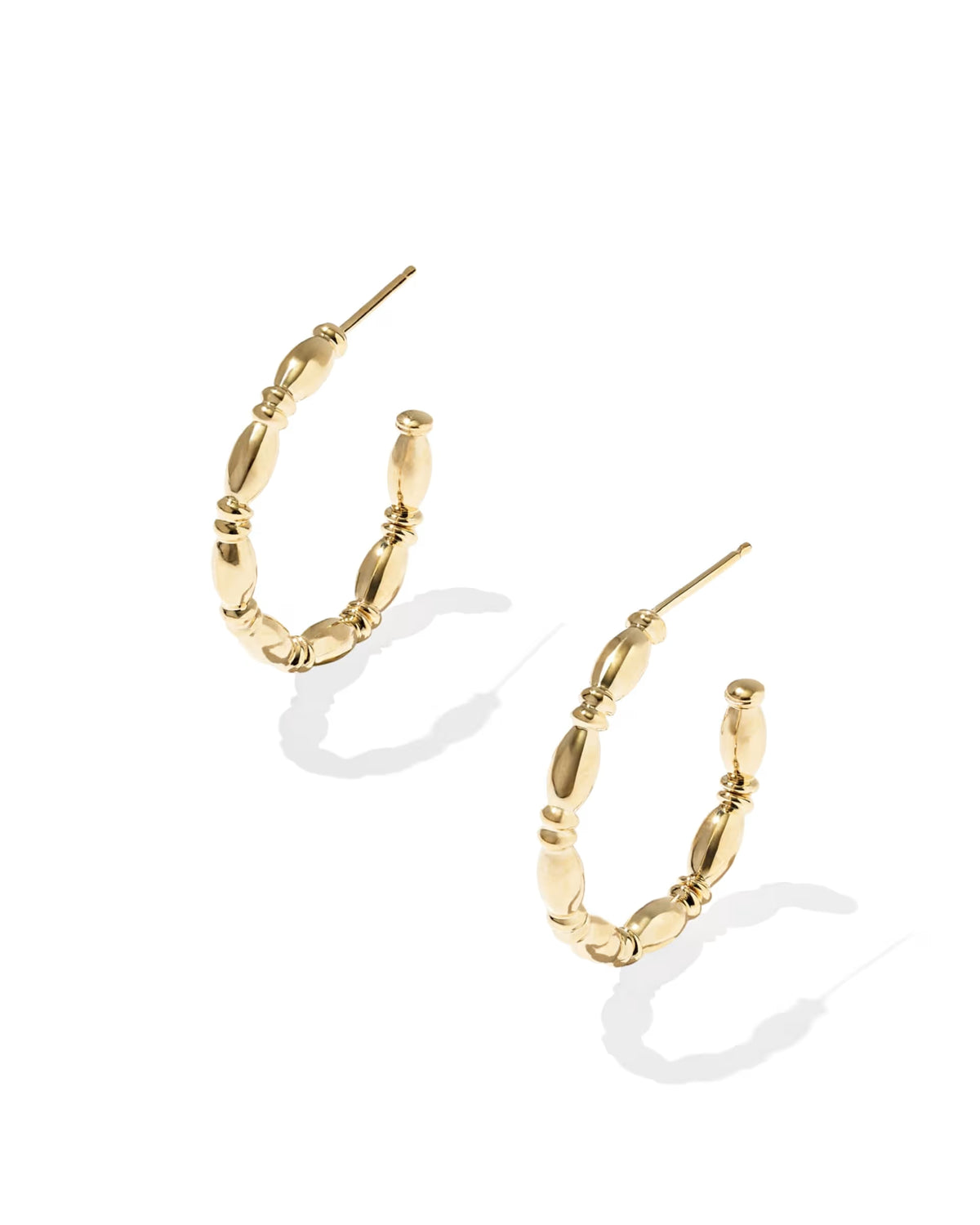 A pair of gold hoop earrings with a textured, beaded segmented design, displayed on a clean white background with soft drop shadows.
