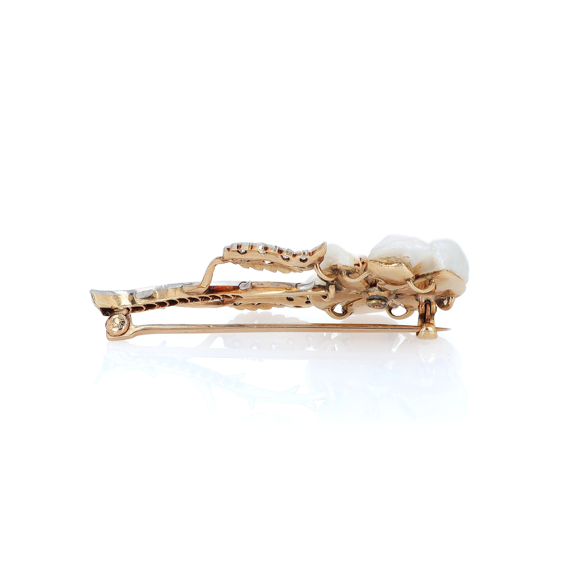 Platinum and yellow gold flower design pin with pearl petals and diamond accents on a white background