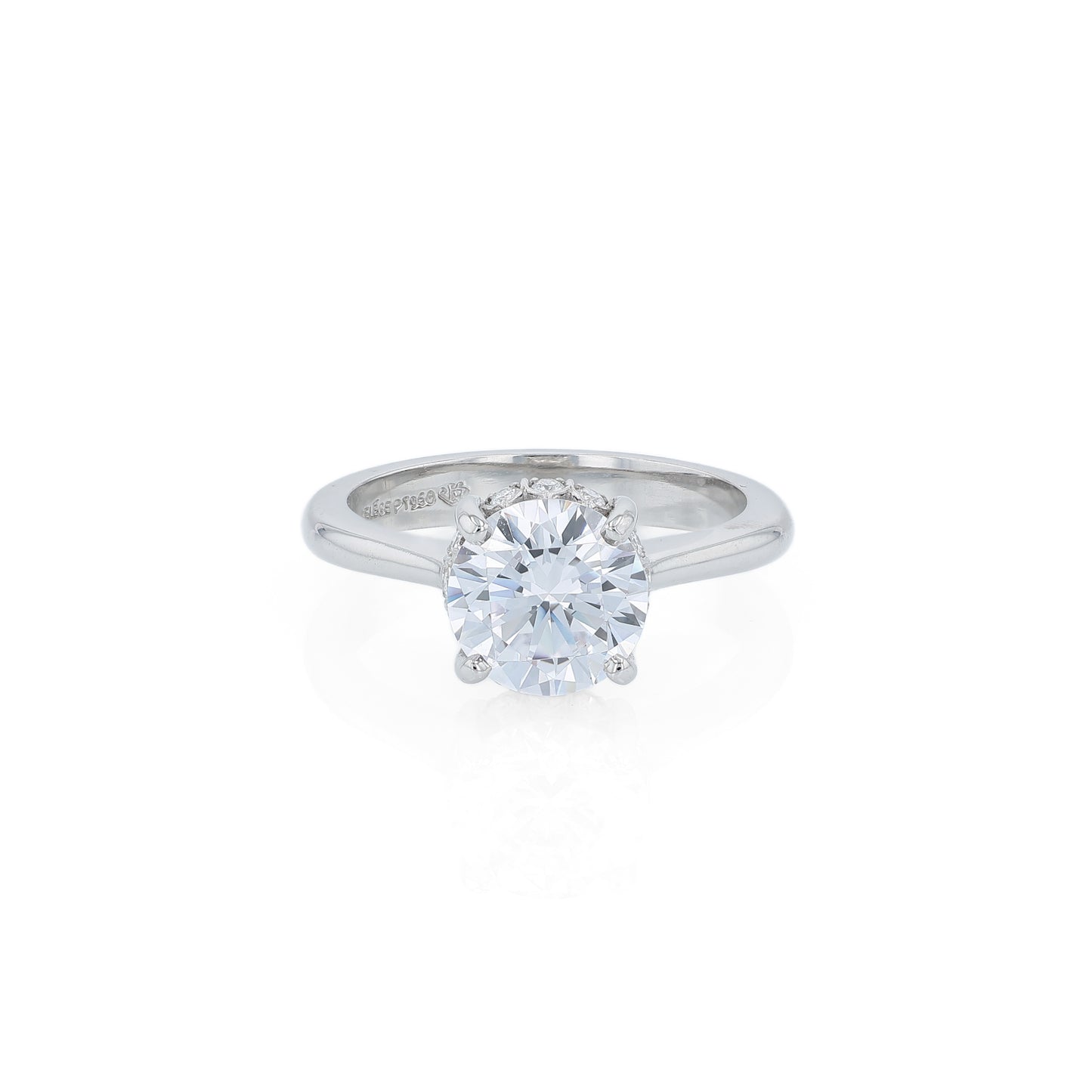 Platinum diamond engagement ring with diamond accents under the head and a round cubic zirconia center on a white background