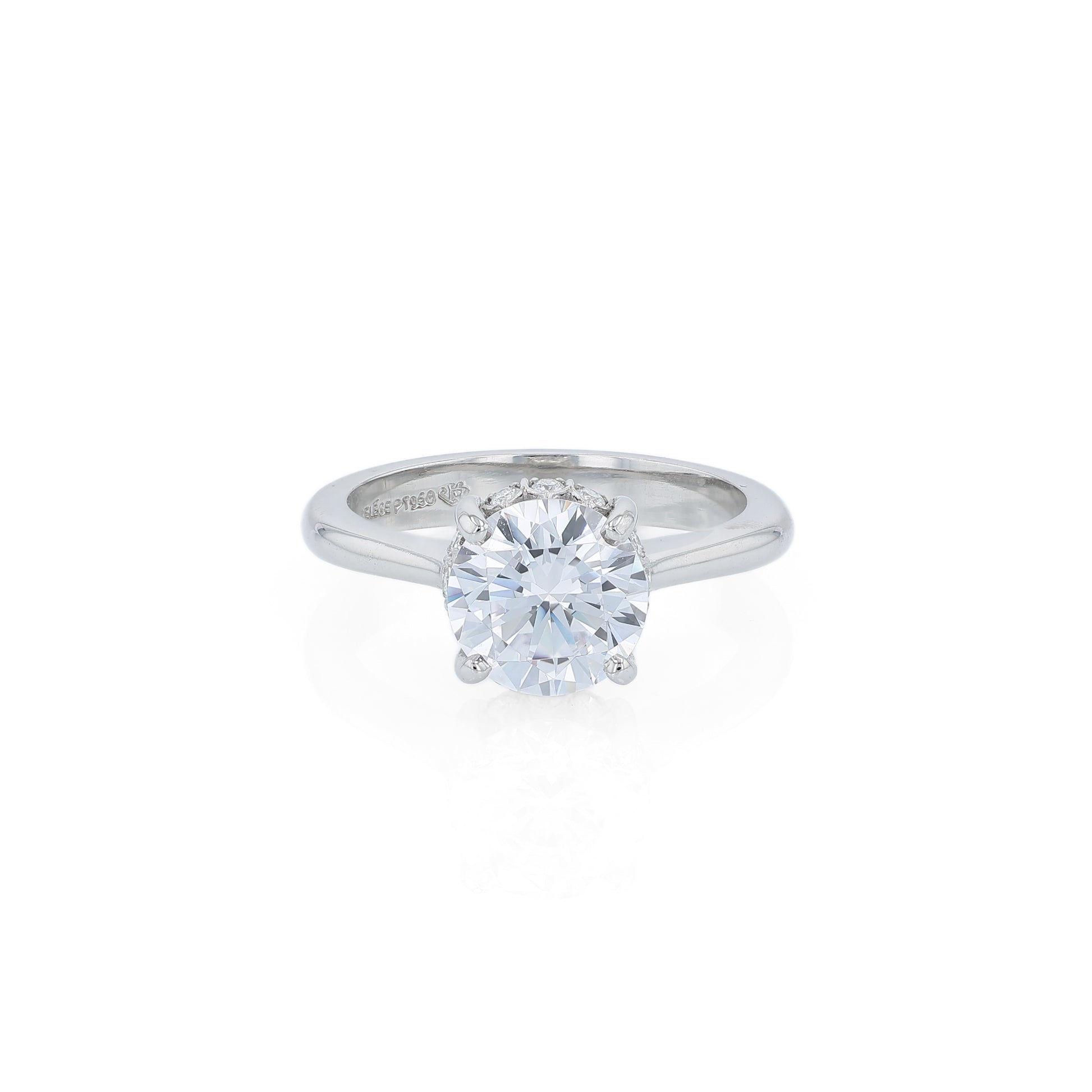 Platinum diamond engagement ring with diamond accents under the head and a round cubic zirconia center on a white background