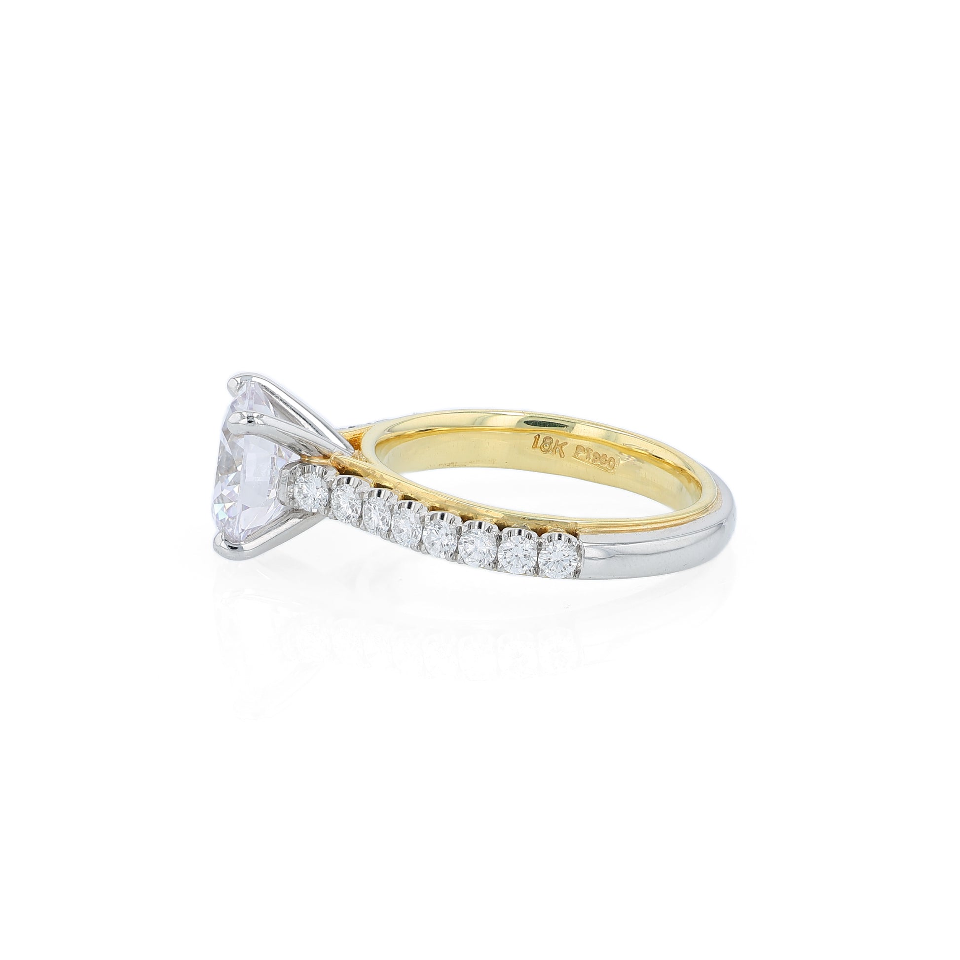 Two-tone diamond engagement ring with diamond accents and a round cubic zirconia center on a white background