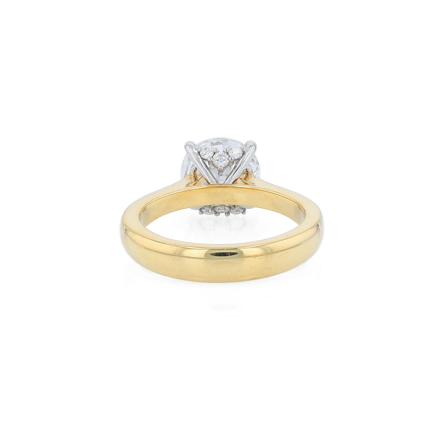 Yellow gold and platinum diamond solitaire engagement ring with diamond accents and a round cubic zirconia center on a white background
