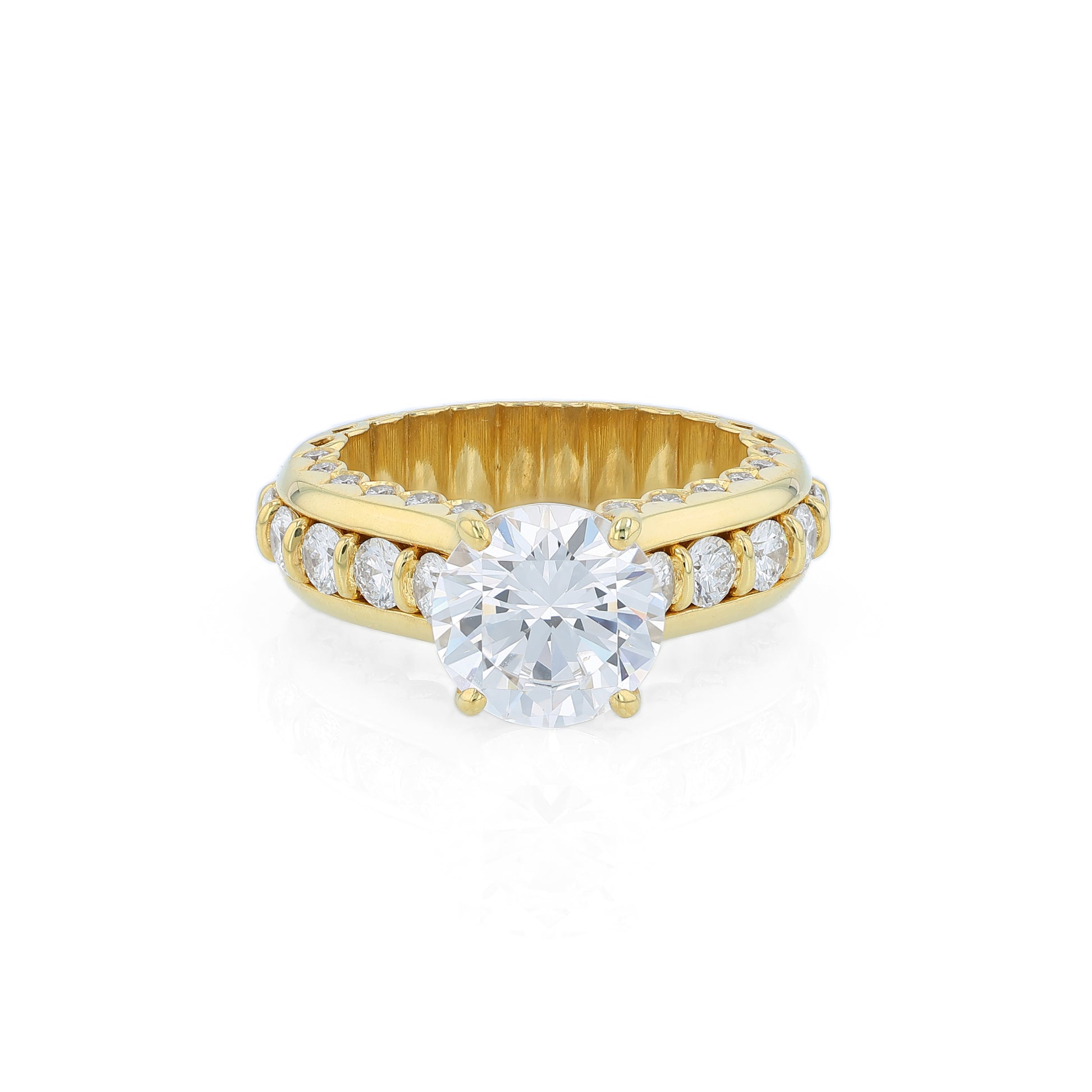 Yellow gold diamond engagement ring with diamond accents and a round cubic zirconia center on a white background