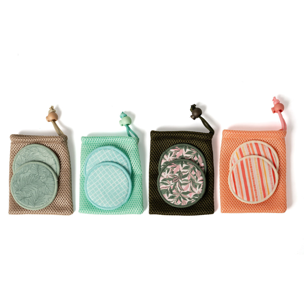Set of four reusable cotton pads in different designs with carrying cases on a white background