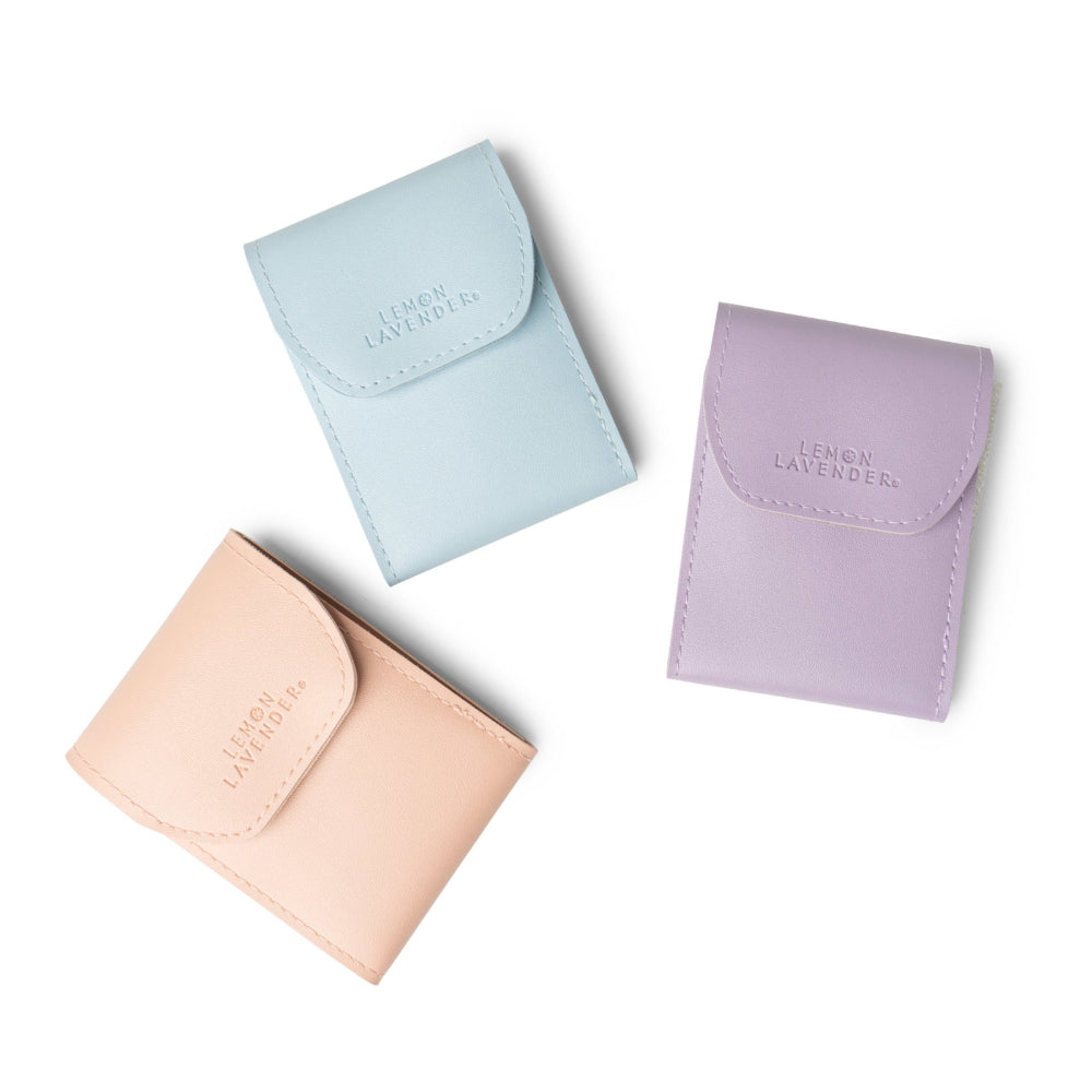 Three small leather pouches in pastel colors on a white background