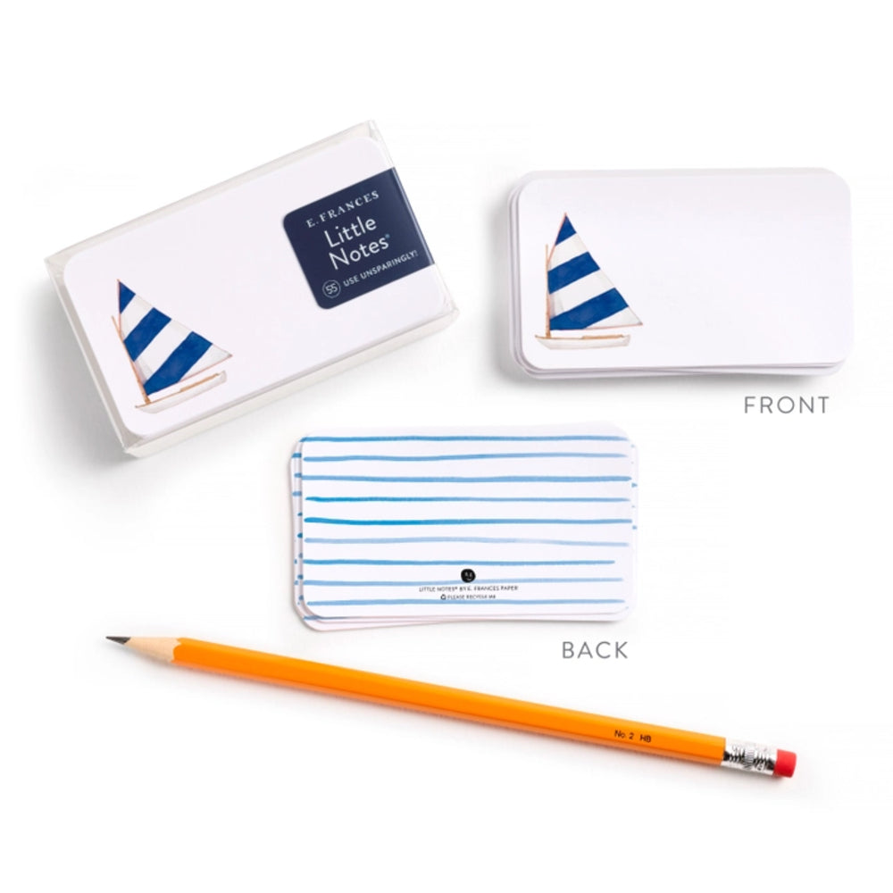 Set of notebook with sailboat design, pencil, and packaging on a white background.