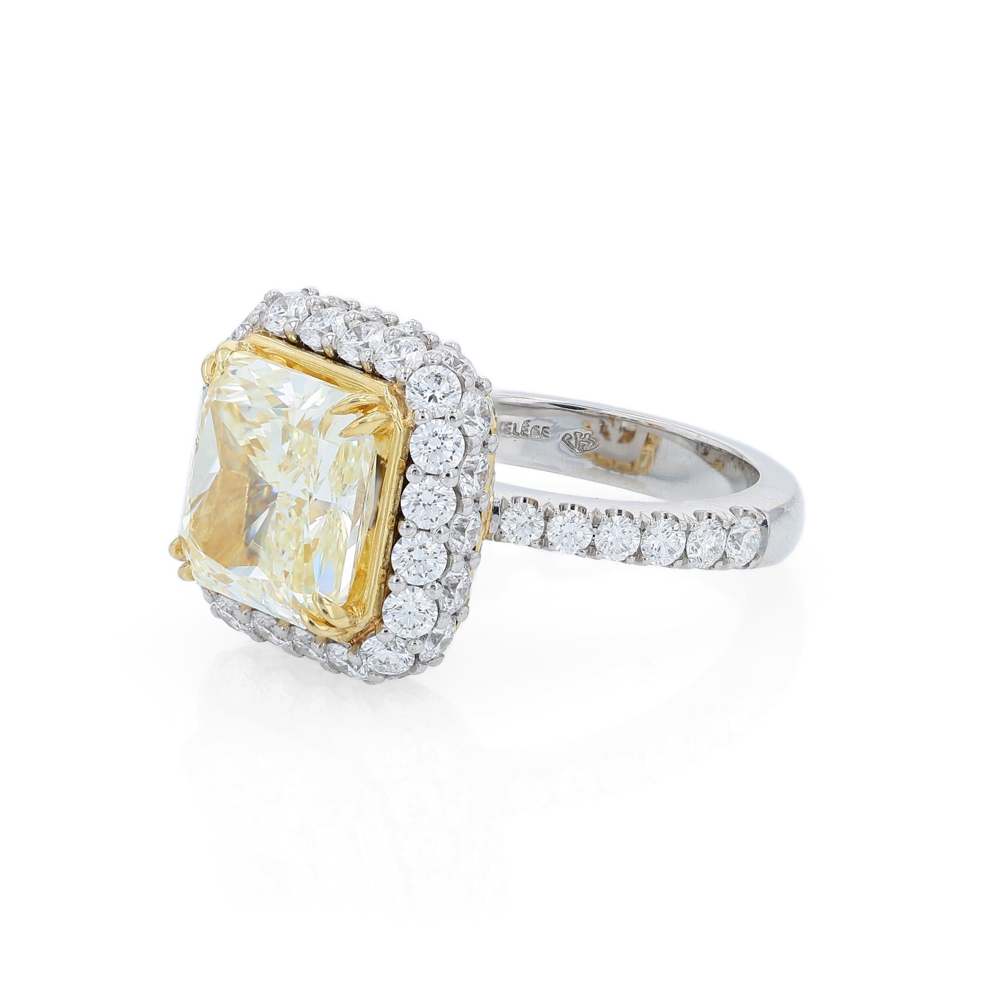 Platinum diamond halo ring with a yellow diamond center on a white background