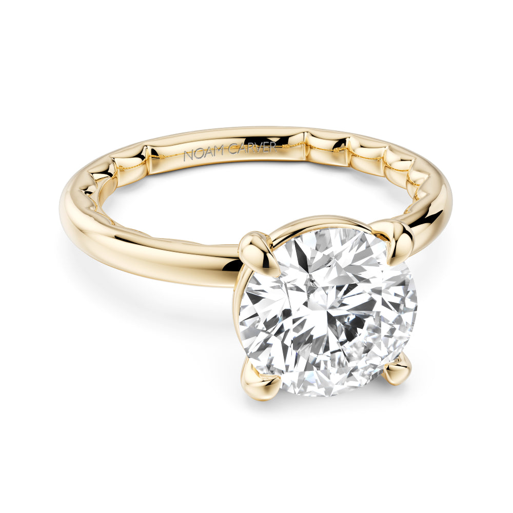 Gold Noam Carver ring with a large round diamond on a white background
