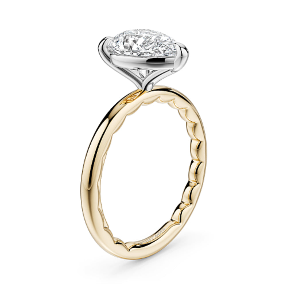Gold Noam Carver ring with a pear-shaped diamond on a white background