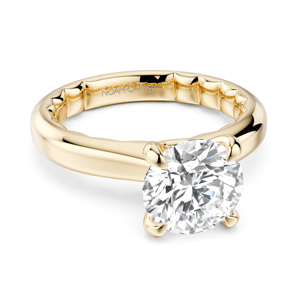 Gold Noam Carver ring with a round diamond on a white background