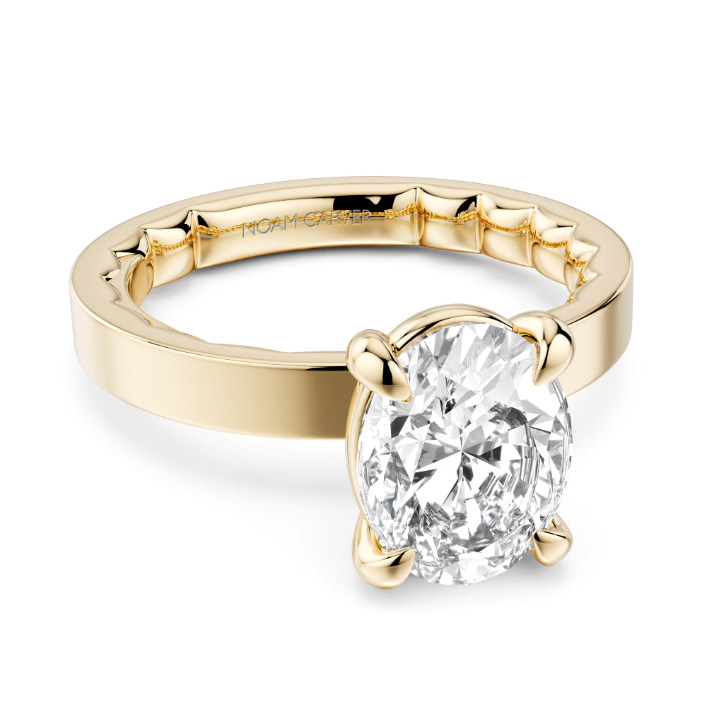 Gold Noam Carver ring with a large oval diamond on a white background
