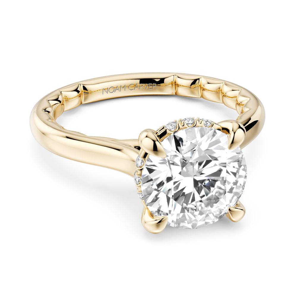 Gold Noam Carver ring with a large Round diamond center and round diamond hidden halo on a white background