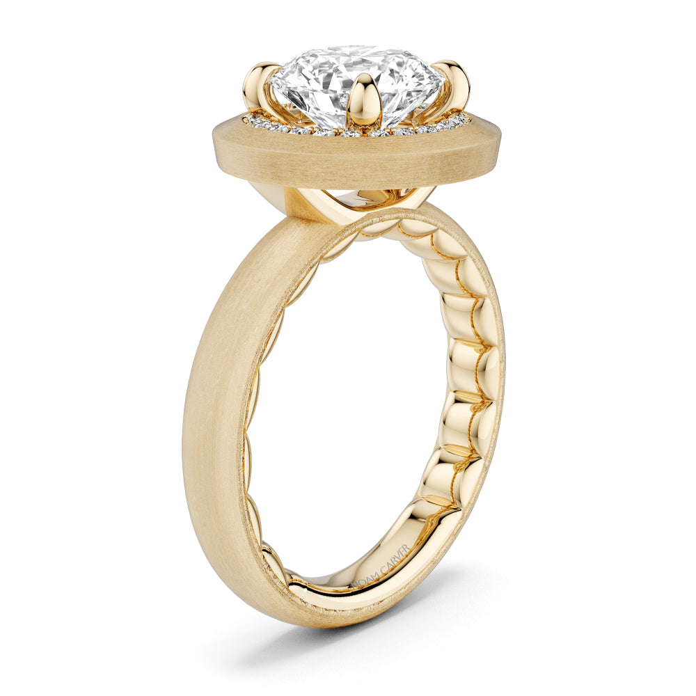 Brushed gold Noam Carver ring with a large diamond and smaller surrounding diamonds on a white background