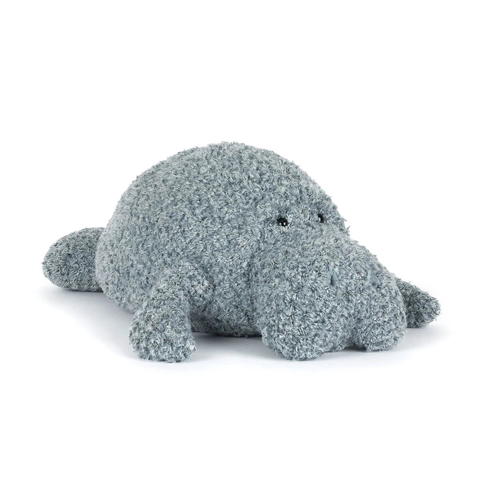 Angled side photo of an grey manatee stuffed animal with textured surface on a white background.