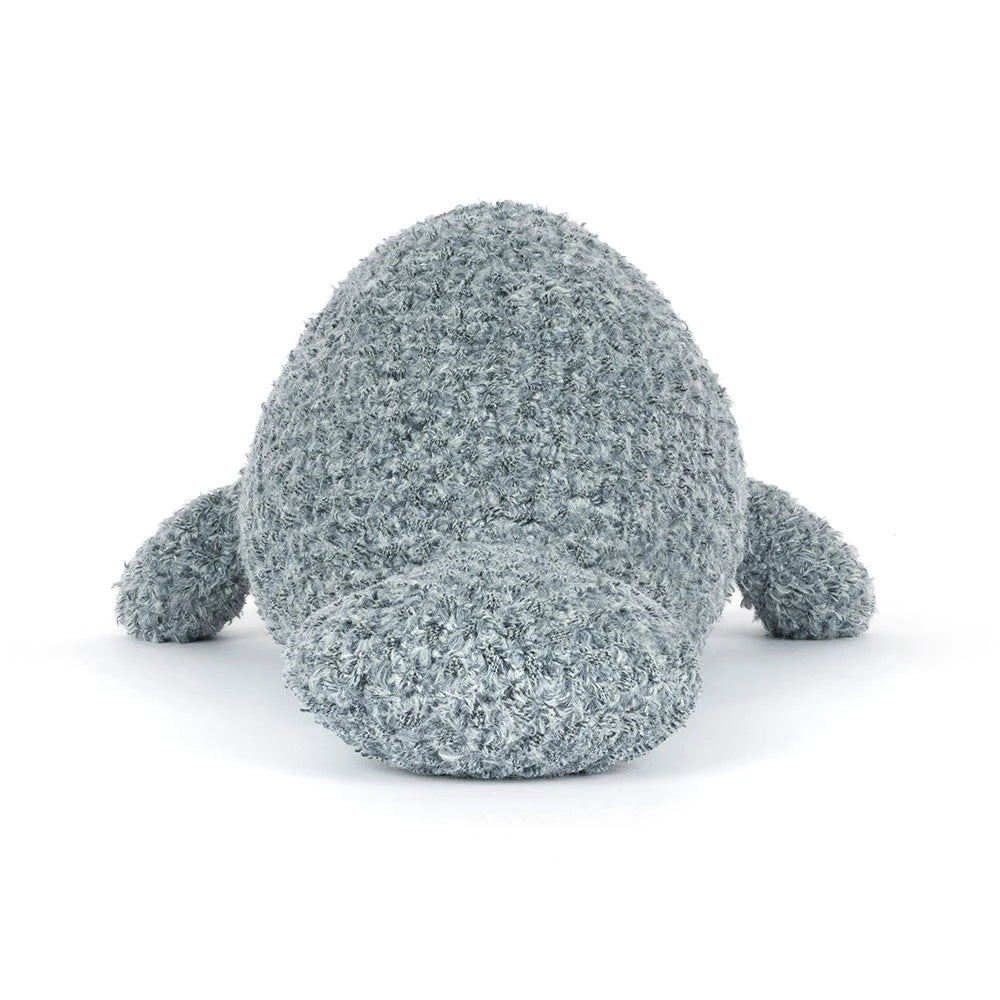 A photo of the back of a grey manatee stuffed animal with textured surface on a white background.