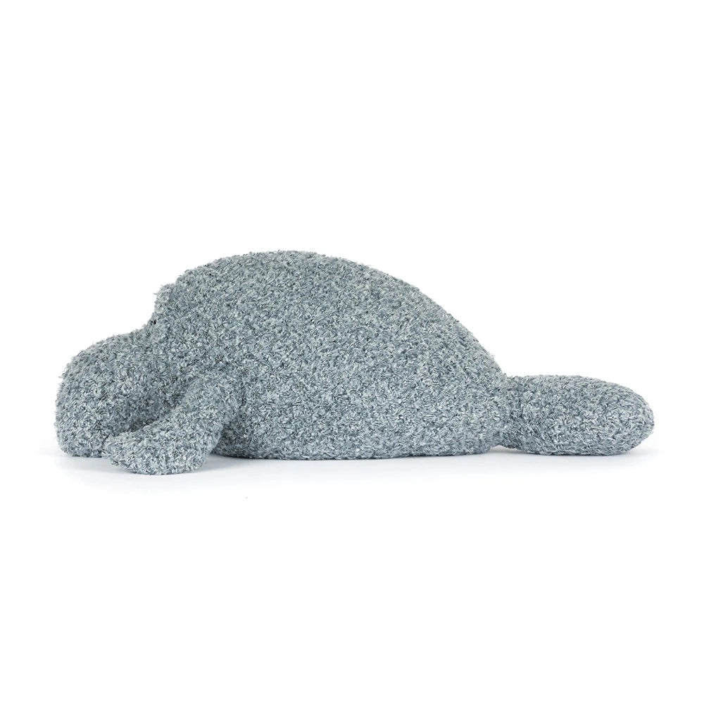 Side photo of an grey manatee stuffed animal with textured surface on a white background.